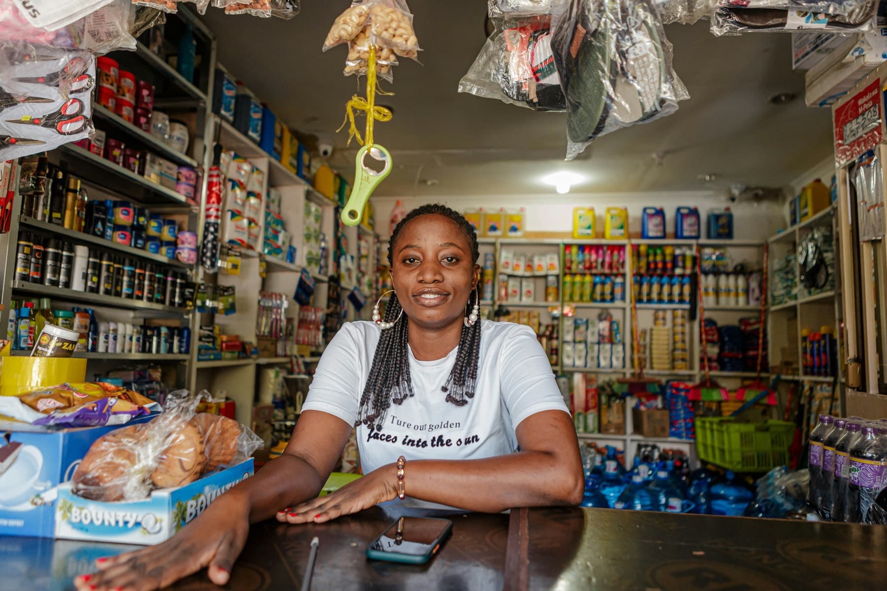 A shop owner smiling behind the counter of her store