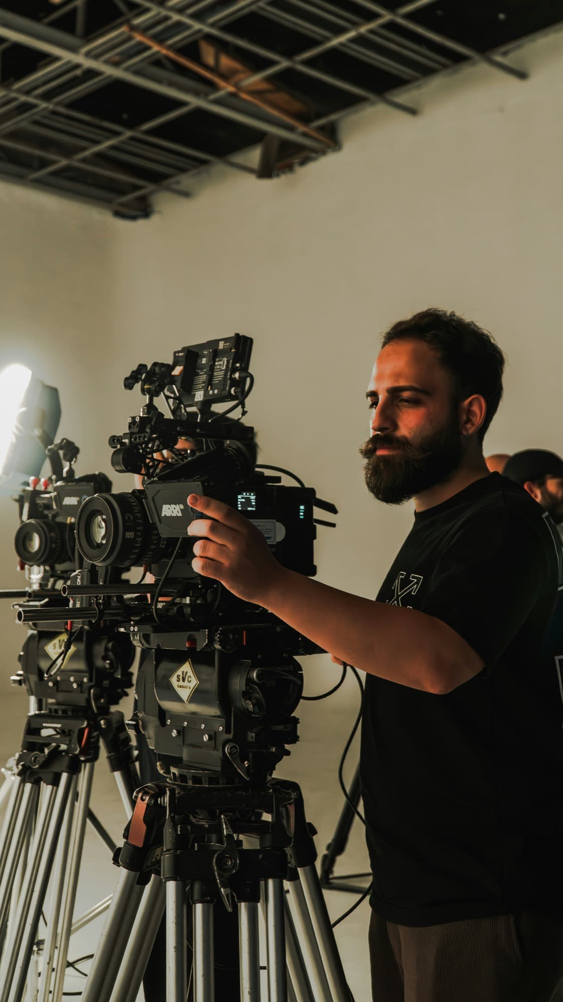 A cinematographer setting up a cinema camera on a production