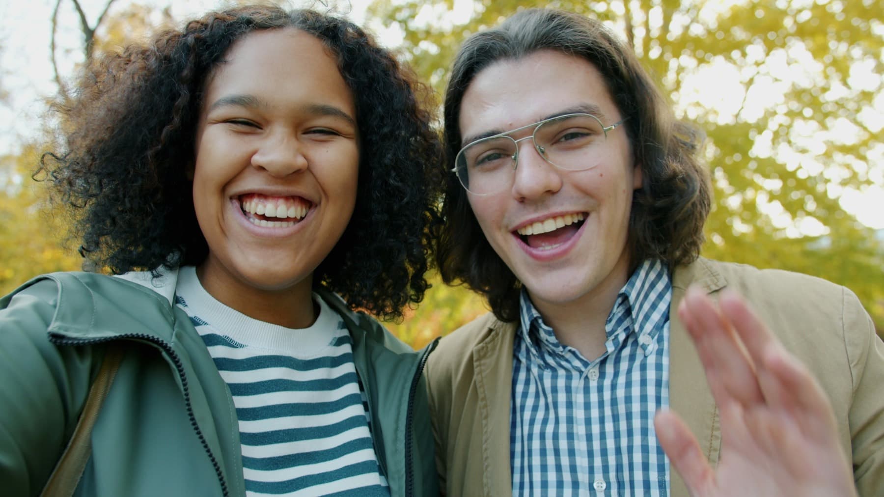 Two members of a hiring team smiling and waving on a video call